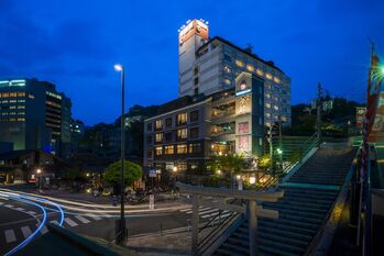 차하루 하나레 도고 유메쿠라 숙소 일대 건물과 도리이가 선 돌계단의 저녁 풍경