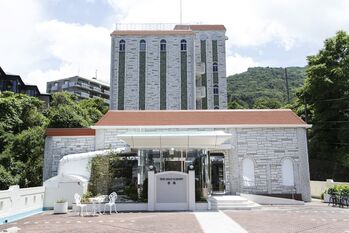 그랜드 리조트 아리마 돌벽 무늬 외벽과 유리 현관이 있는 호텔 정면