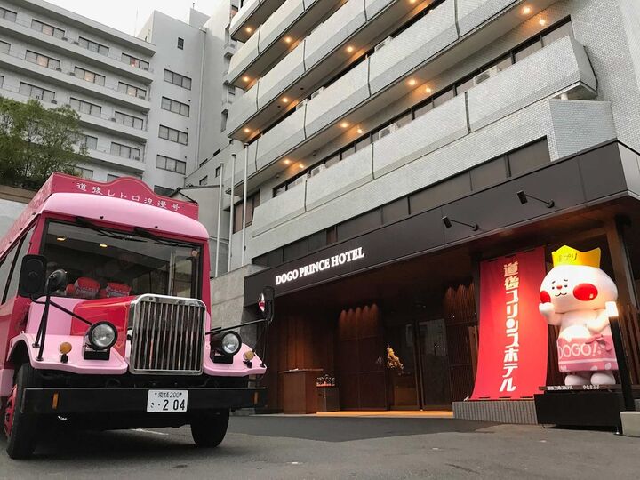 도고 프린스 호텔 호텔 현관 앞에 선 분홍색 보닛버스와 캐릭터 인형