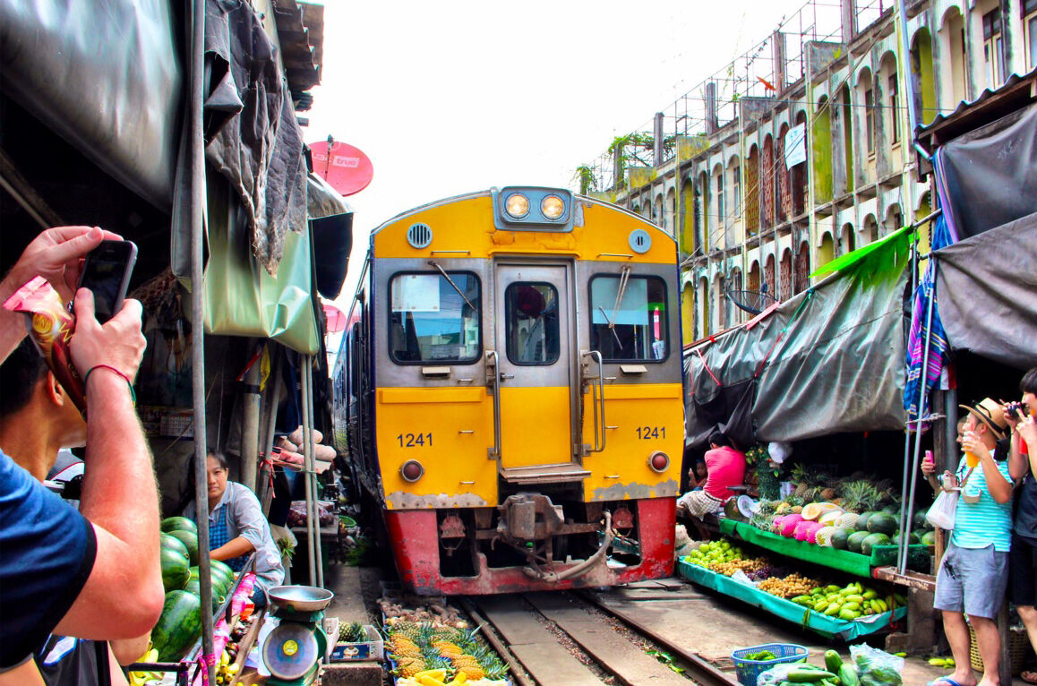 해 질 녘 암파와 수상시장의 조명이 켜진 강변 상점들과 반딧불 투어를 기다리는 보트들