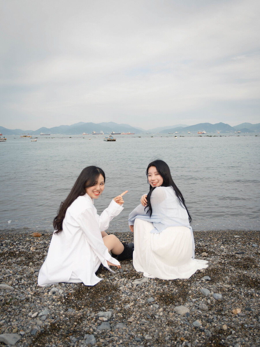 여수 바다와 배를 배경으로 앉아 있는 두 사람의 스냅