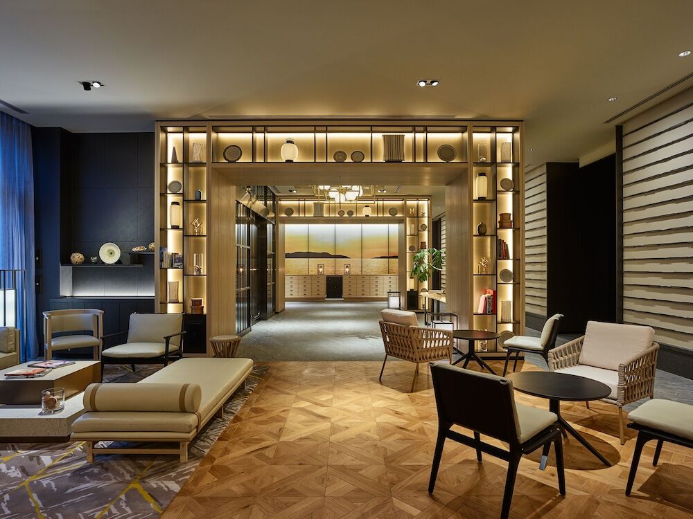 따뜻한 원목 자재와 세련된 조명이 어우러진 호텔 로비의 고급스러운 라운지 전경