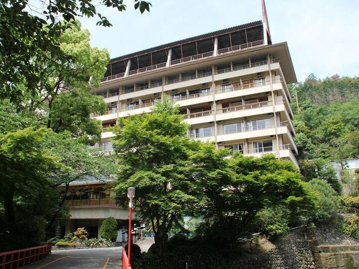 후시오카쿠 나무 사이로 보이는 고층 본관과 붉은 난간 다리